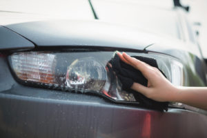 close up of someone cleaning a car headlight