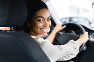 Woman behind the steering wheel turned around smiling