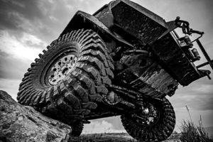 off roading vehicle, equipped with different off roading gears, climbing over a rock