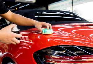 Red sport car getting a protective coating