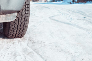 A Car Wheel On Snow and Salt covered Road