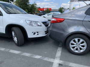 A car hit another parked car in a parking lot