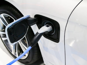 an EV charging port connected to an electic vehicle at a EV charing station