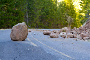 Big rocks in the middle of an automobile road