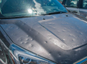 Dented car hood caused by hail storm
