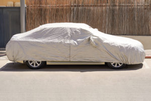 A car parked with a silver protective cover;